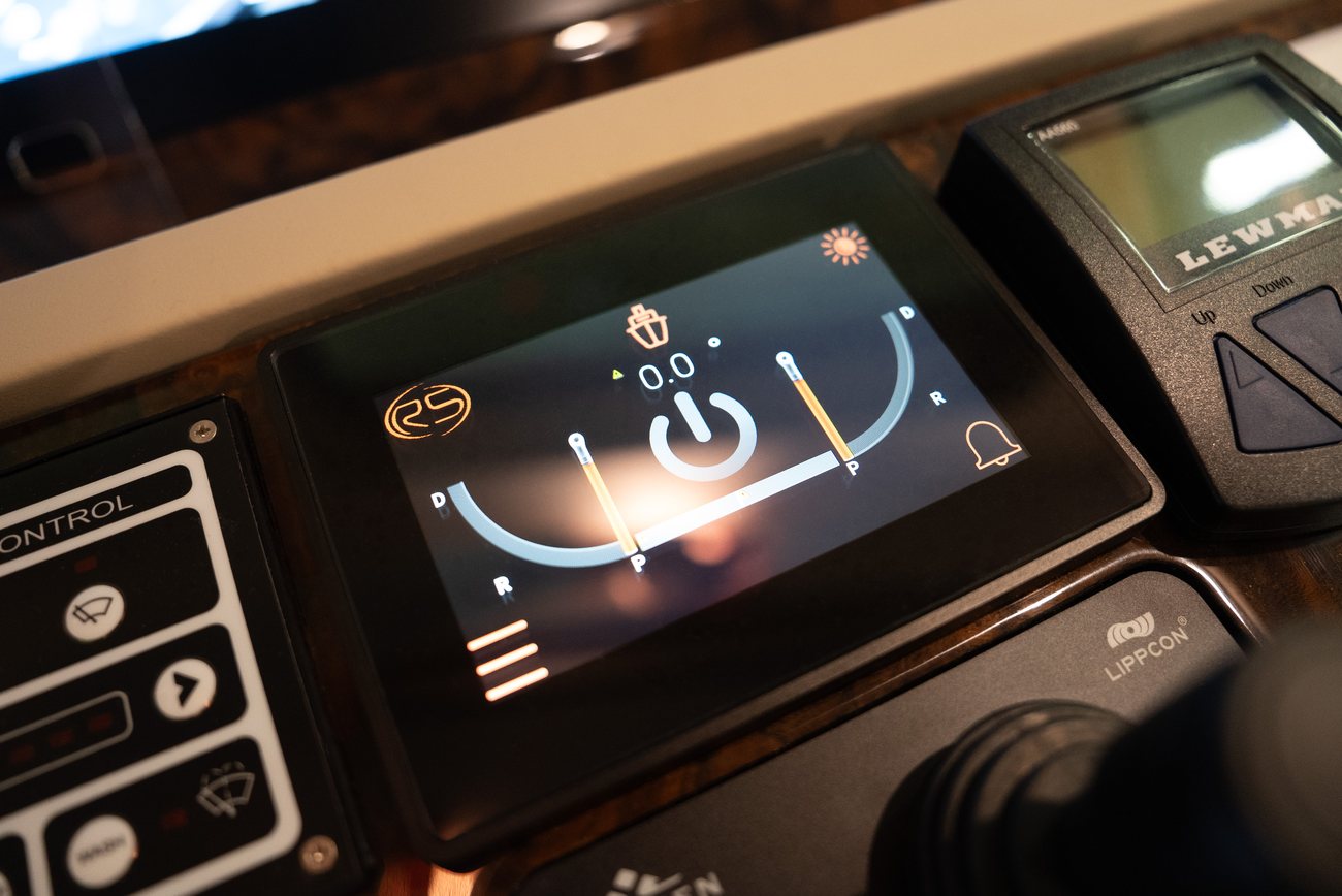 A RotorSwing touchscreen set into a yacht helm console beside the thruster panel, showing port and starboard indicators at zero degrees
