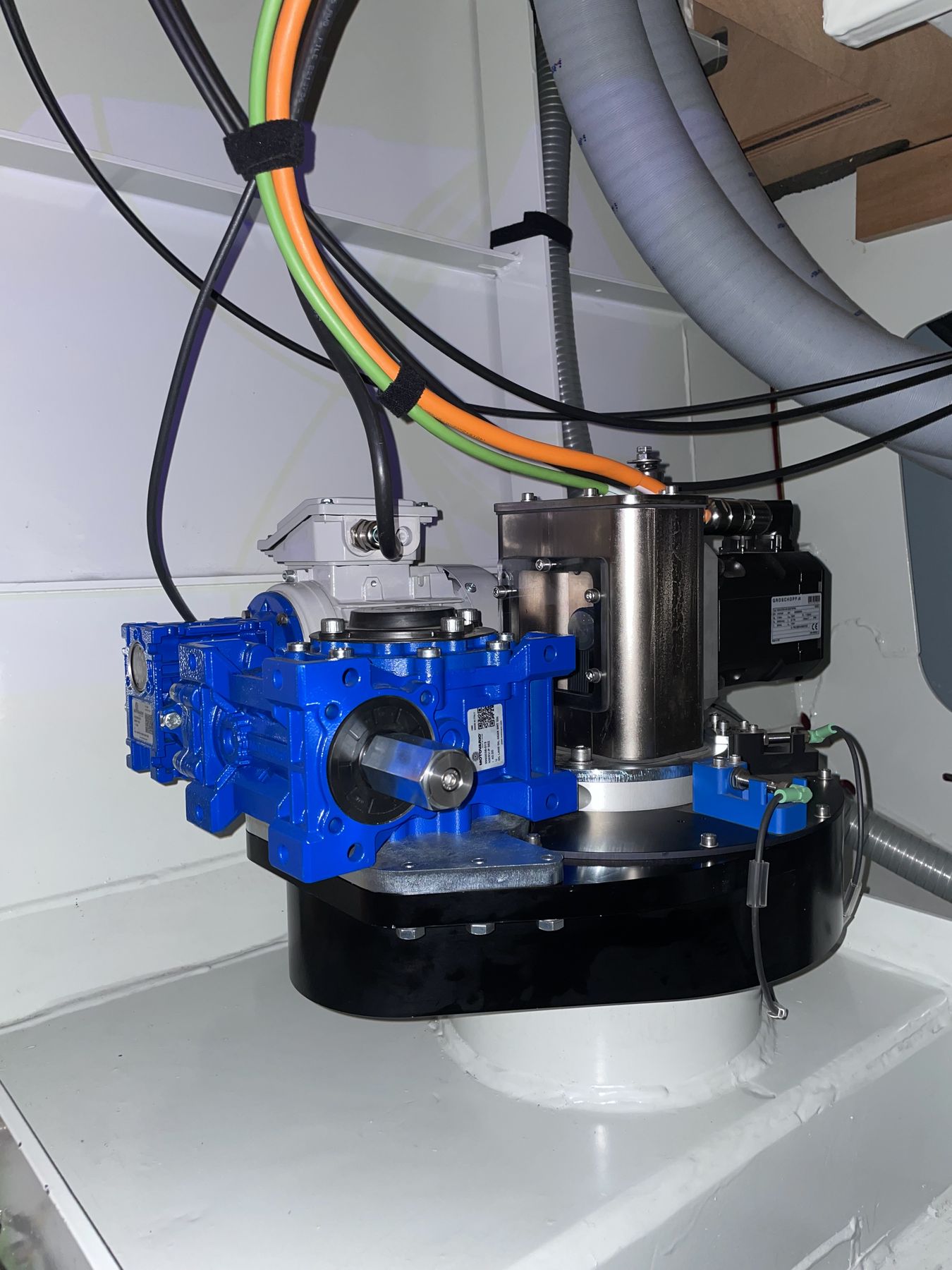 A RotorSwing drive unit fitted inside a hull: the blue gearbox and actuator on their base plate, cabling led away overhead