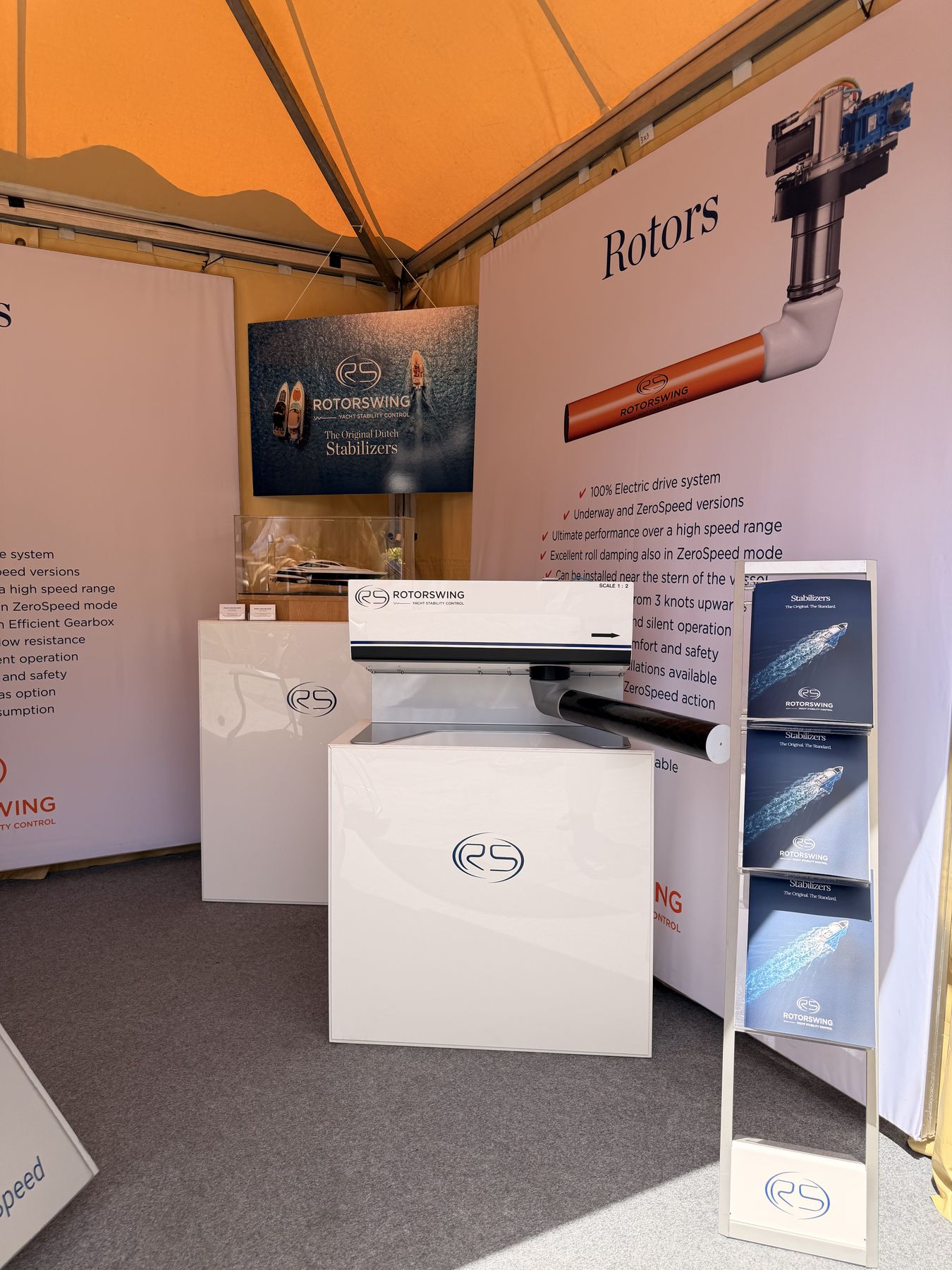 The RotorSwing stand at the Palma International Boat Show, an orange rotor on the counter beneath the Rotors panel
