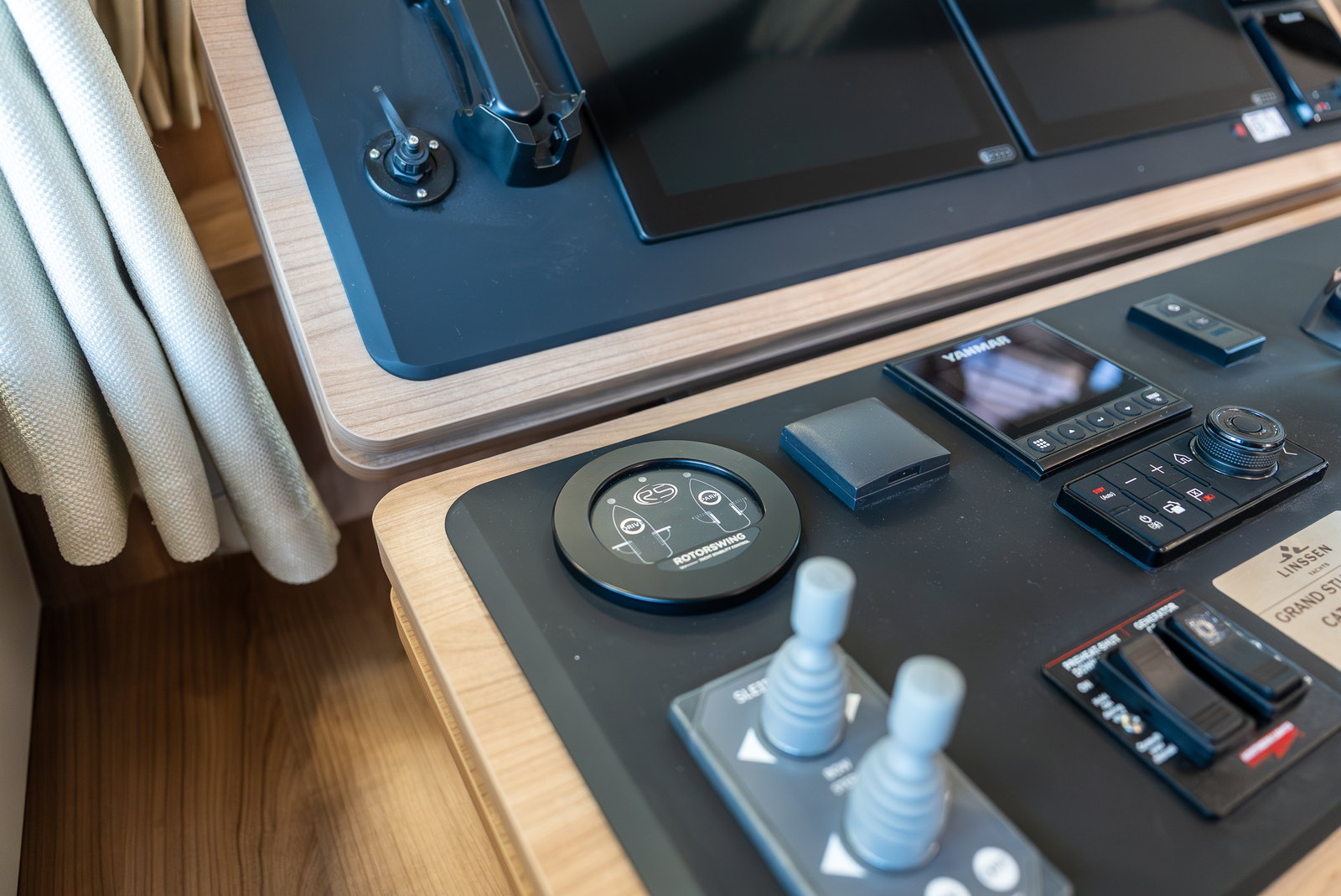 The round RotorSwing control dial set into a yacht helm console beside the engine display, throttle levers and chart plotter