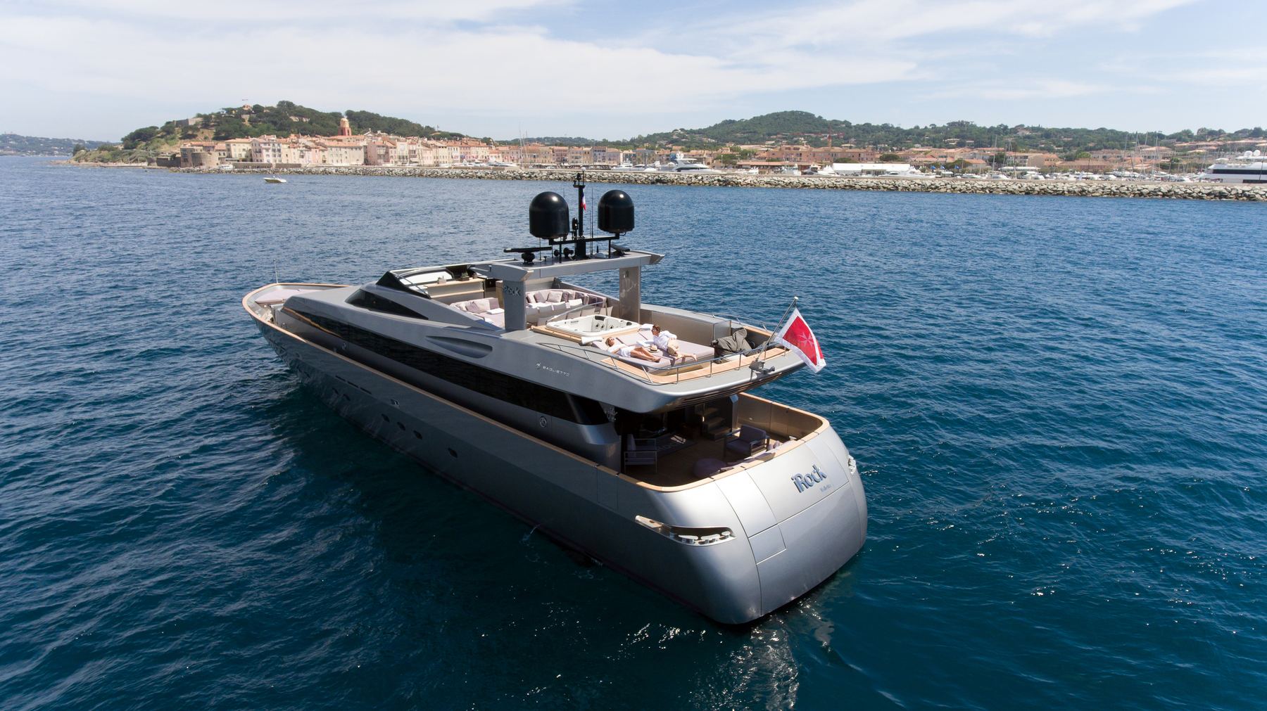 MY iRock seen from above at anchor beside a Mediterranean shoreline